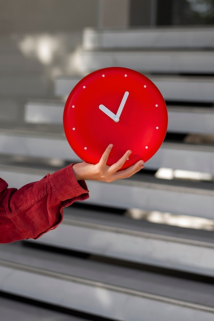 Free photo hand holding wall clock still life