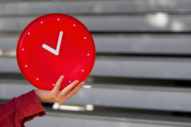 Free photo hand holding wall clock still life