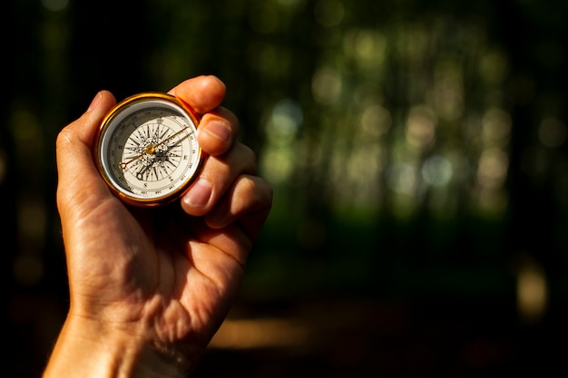 Free photo hand holds a compass with blurred background