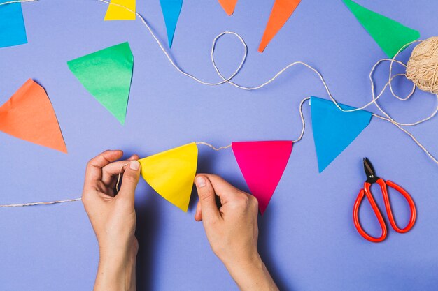 Hand making colorful bunting on purple backdrop