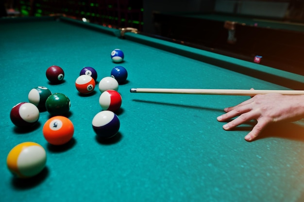 Free photo hand man holding billiard cue to shoot balls