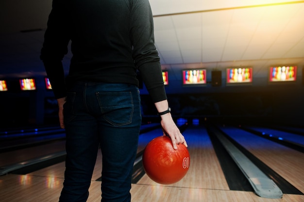 Hand of man player with bracelet holding bowling ball