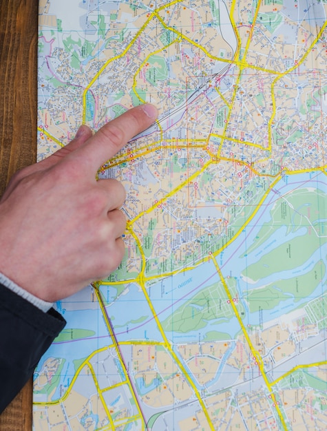 Free photo hand of person pointing at map