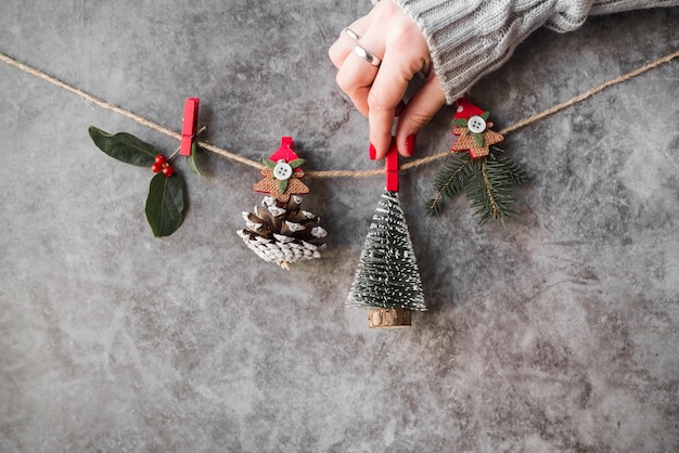 Free photo hand pinning christmas decorations on thread