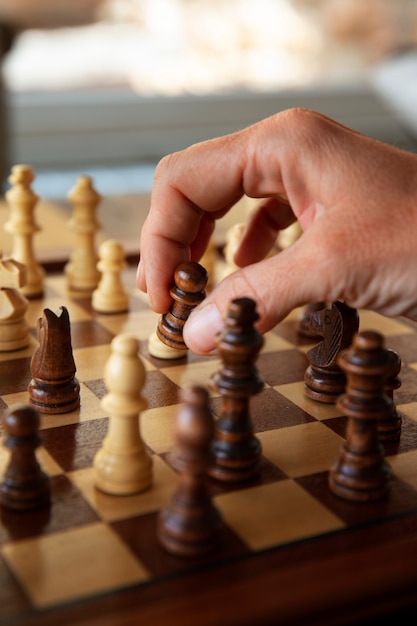 Free Photo hand playing chess on classic board