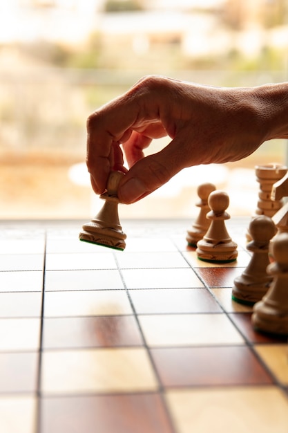 Hand playing chess on classic board