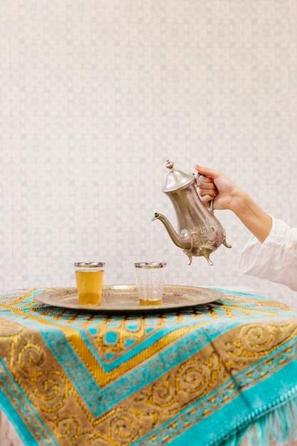 Free Photo hand pouring tea into glass