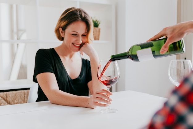 Hand pouring wine for girlfriend