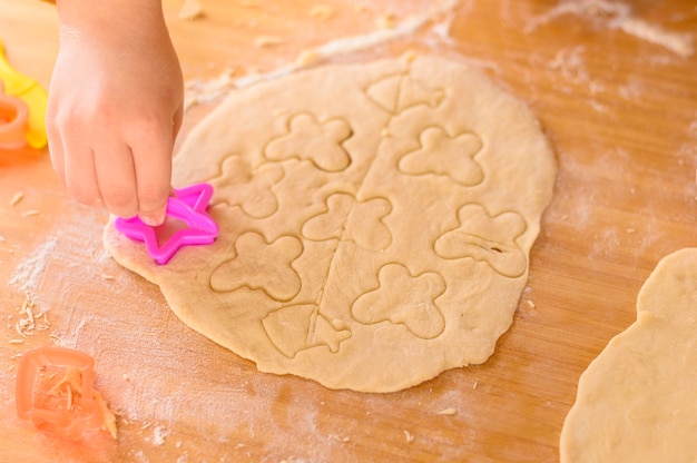 Free Photo hand puts butterfly shapes on dough