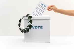 Free photo hand puts vote bulletin into vote box and a crown