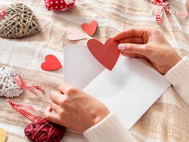 Hand putting heart in envelope