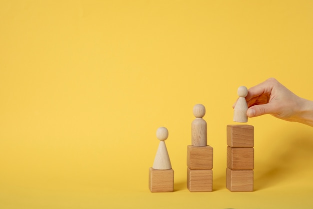 Free photo hand putting pawn on wooden cubes