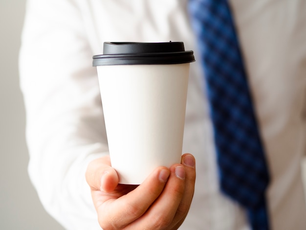 Free photo hand showing coffee cup mock-up