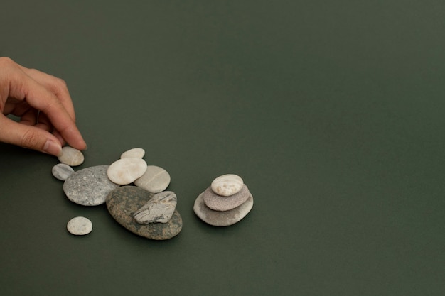 Free photo hand stacking zen stones on the sand wellness background