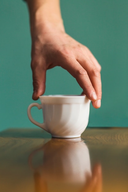 Free photo hand taking ceramic cup