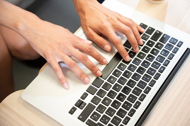 Hand typing on laptop top view