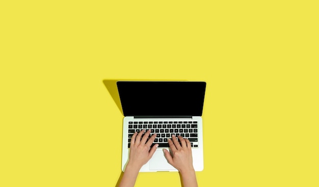 Hand using gadgets, laptop on top view, blank screen