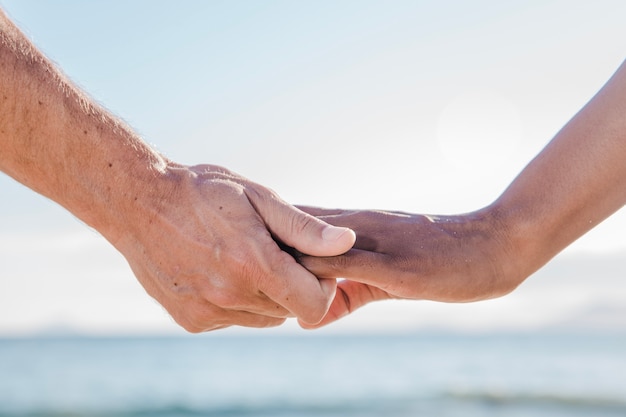 Free photo hand view of couple at the beach