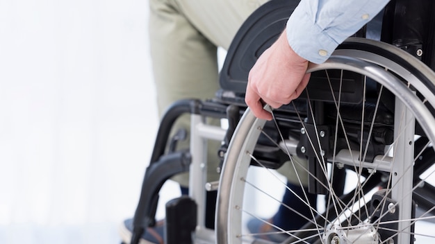 Free Photo hand on wheelchair wheel close-up