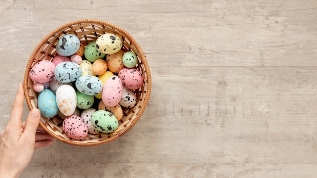 Free photo hand with basket full of eggs for easter