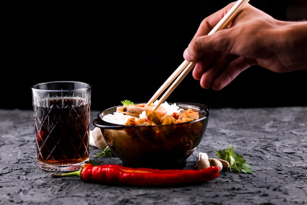 Free Photo hand with chopsticks and rice bowl