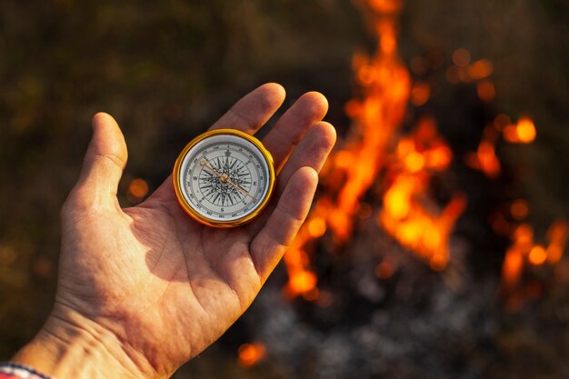 Hand with compass and fire flames along