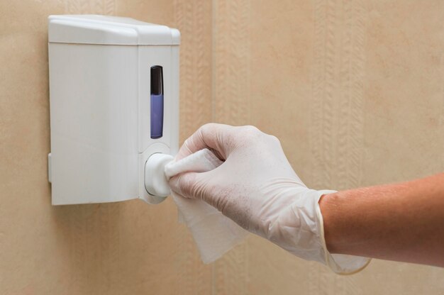 Hand with glove disinfecting soap dispenser