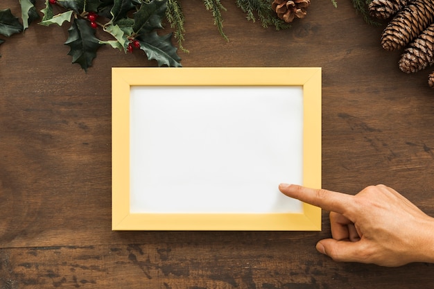 Hand with photo frame between snags and twigs