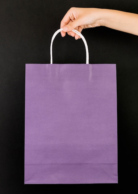 Free photo hand with purple shopping packet