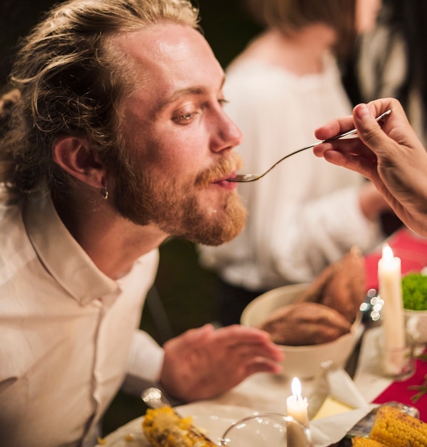 Free Photo hand with spoon feeding man at dinner