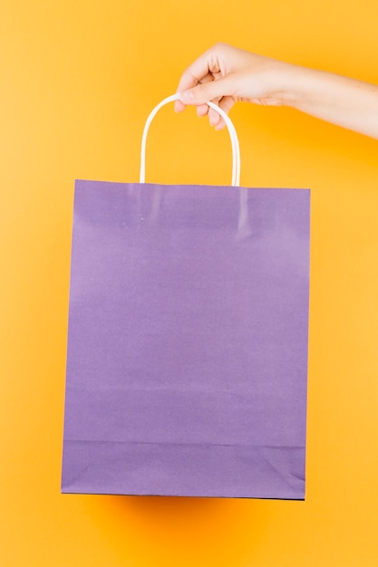 Hand with violet shopping packet