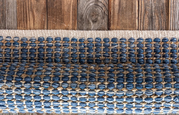 Free photo hand woven geometric denim area rug on wooden floor