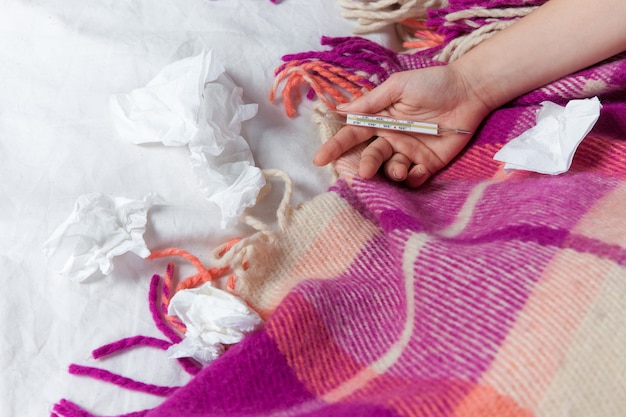 Free photo hand of young sick woman with thermometer