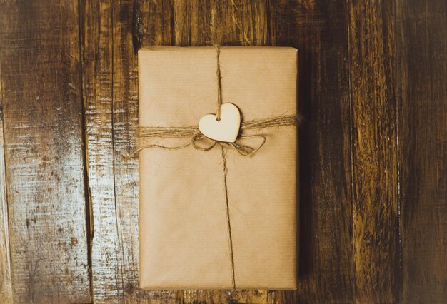 Handcraft gift boxe with red heart on a wooden table Top View