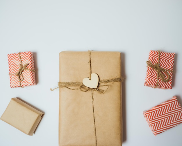 Handcraft gift boxes with red heart on a white table Top view