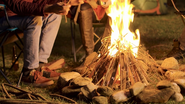 Free photo handheld footage of man making camp fire for his friends in a cold night.