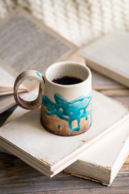 Free Photo handmade cup and books closeup on a wooden surface copy space