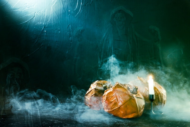 Free photo handmade halloween pumpkins with burning candle and ghost and smoke