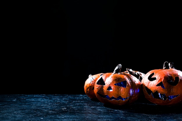 Free Photo handmade pumpkins in halloween style illuminated inside lying on side in darkness