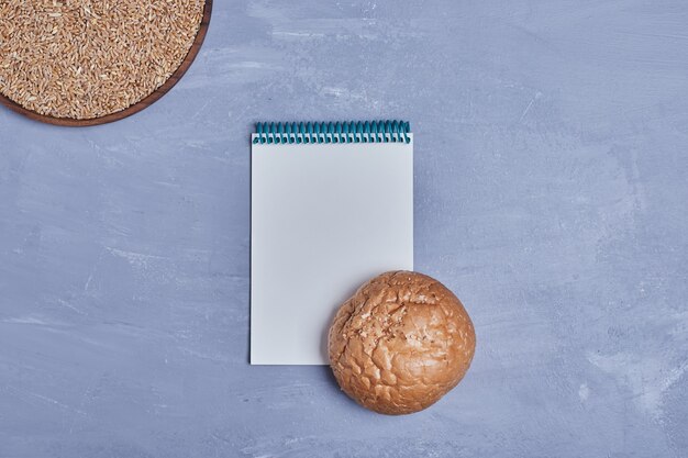 Handmade round bread with a recipe book aside.