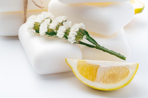 Handmade soap bars and lemon on white background