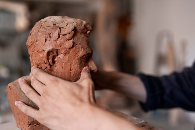 Free Photo hands clay sculpting side view