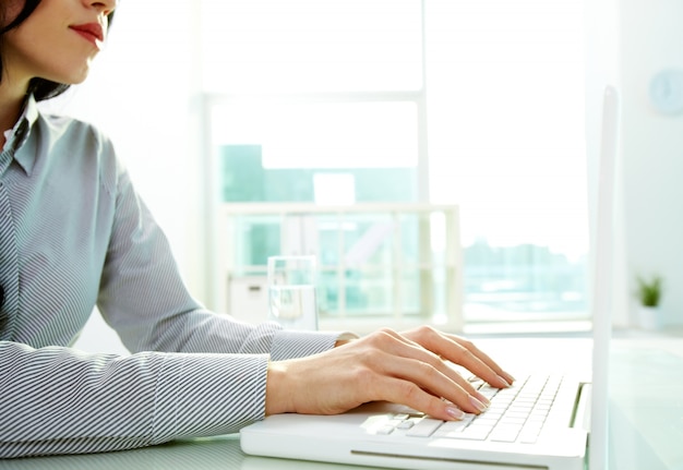 Hands close-up of young woman using a laptop