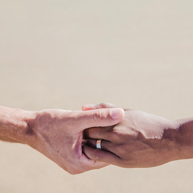 Free photo hands of couple at the beach