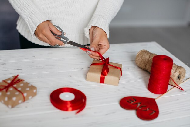 Hands cutting ribbon while wrapping present