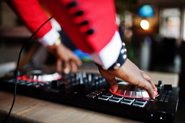 Free photo hands of fashion african american man model dj at red suit with dj controller