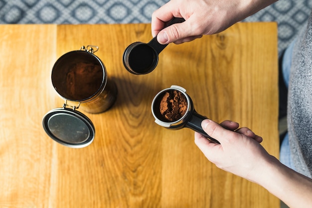 Hands filling filter with coffee powder