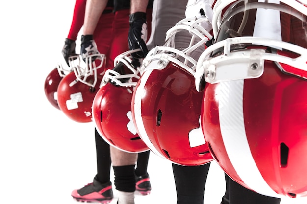 Free photo the hands of five american football players with helmets on white background