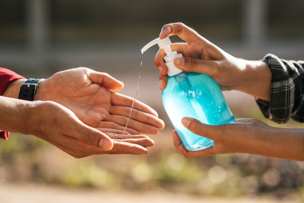 Hands at the gel bottle to wash hands and squeeze for others to wash hands.