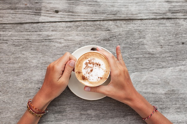 hands hold a cup of coffee.